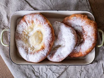 Three sugar-coated baked goods lie in a mold.