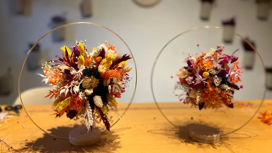 Two flower arrangements in circular frames, tabletop setting.