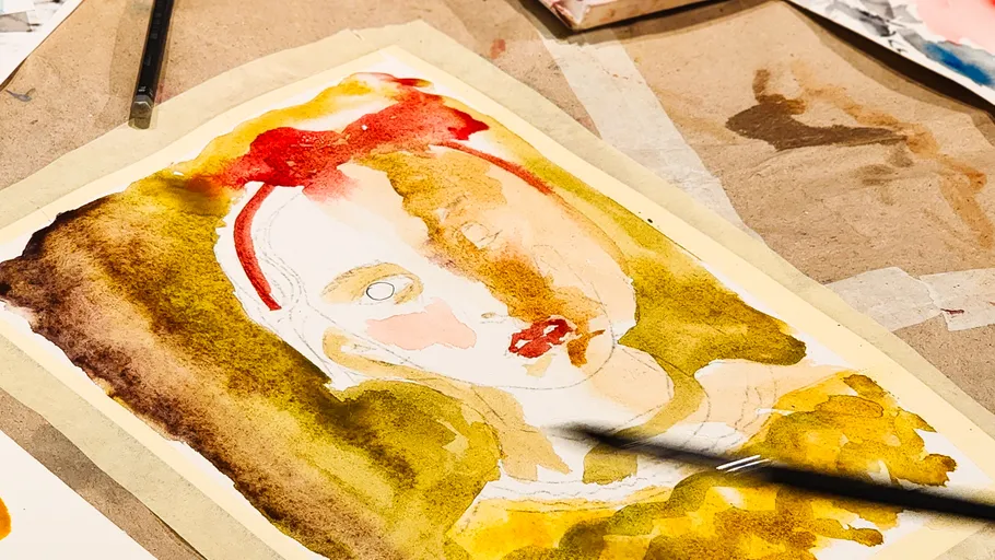 Watercolor portrait on paper, paintbrush visible.