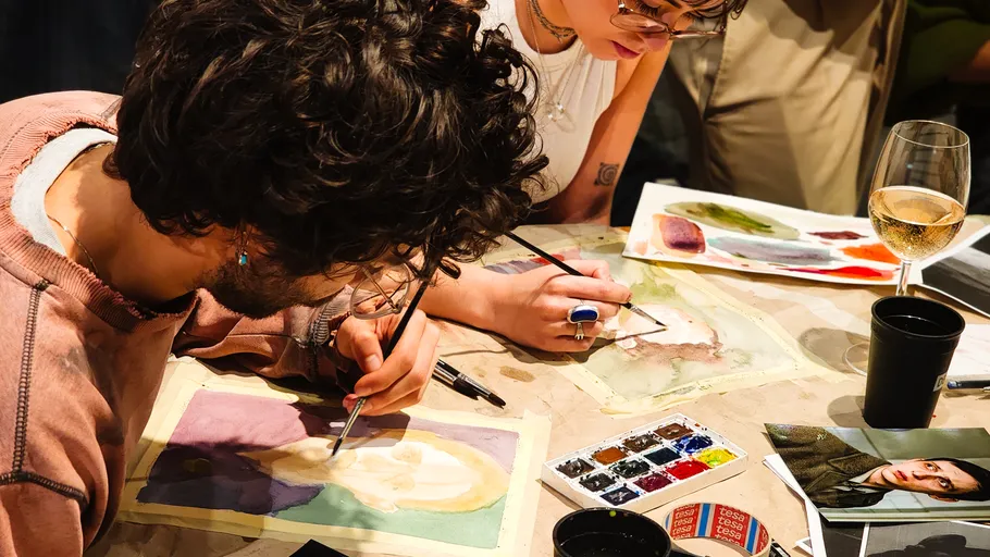 Menschen malen am Tisch mit Aquarellen.