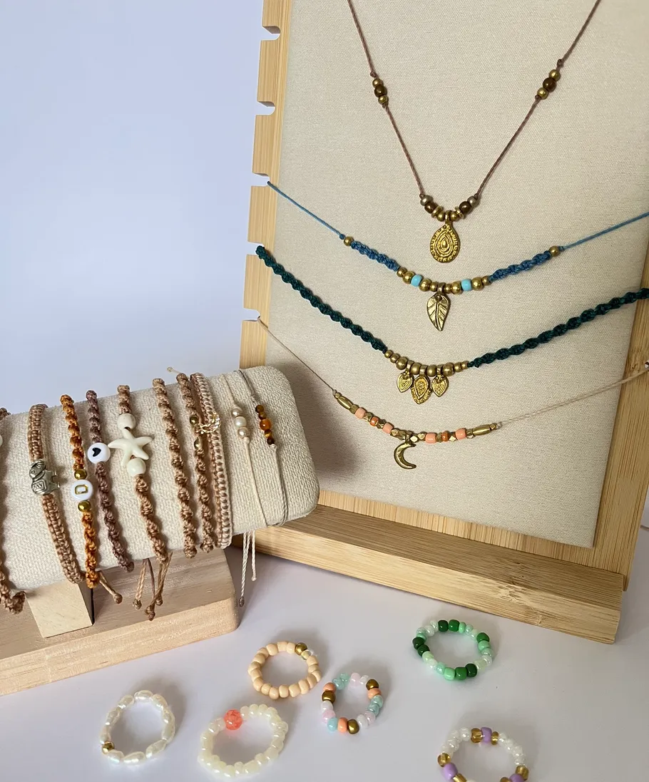 Handmade jewelry displayed on wooden stands.