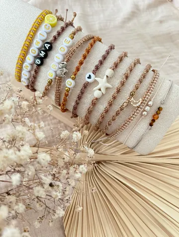 Colorful bracelets displayed on a soft cushion.