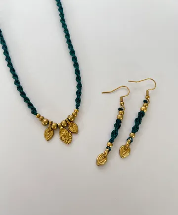 Green necklace and earrings on white background.