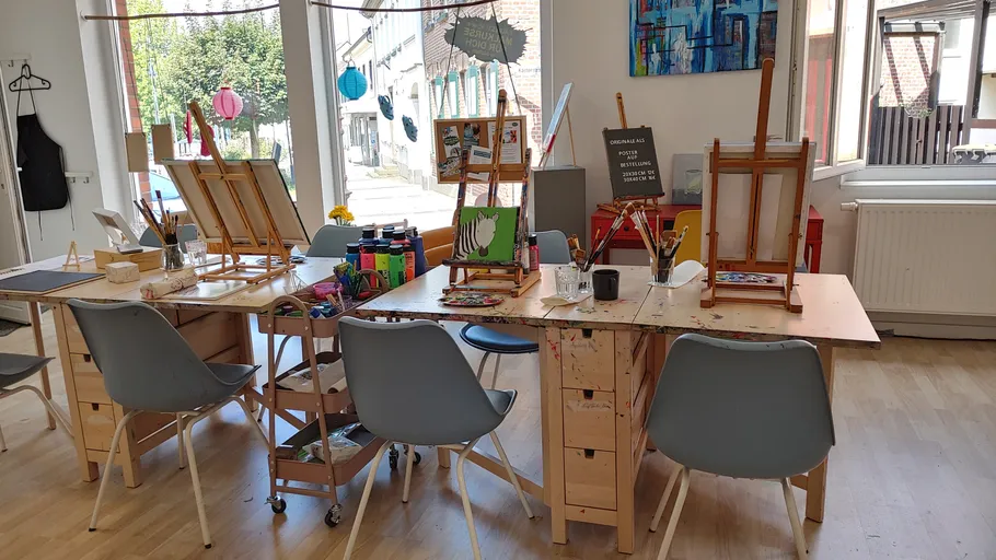 Art studio with easels, chairs, colorful supplies.