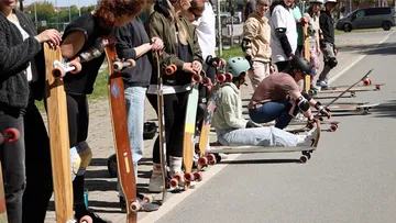 Group of people with longboards on a street.