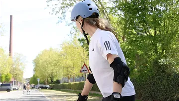 Person rollerblading on a suburban street.