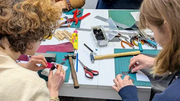 People crafting with tools on a table.