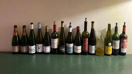 Verschiedene Weinflaschen auf einem Tisch aufgereiht.