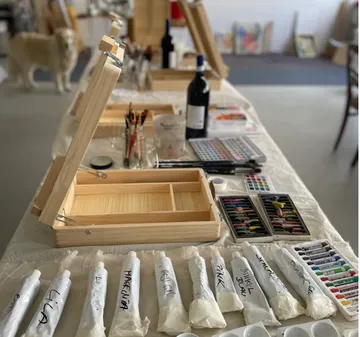 Kunstbedarf auf Tisch in Atelierumgebung.