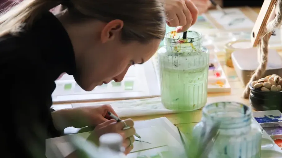 Woman focused on painting in art studio.