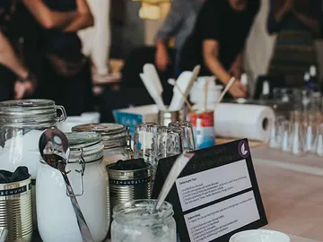 Glasses, spoons and containers are placed on a table.