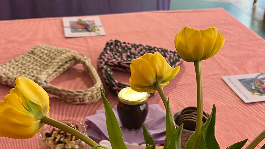 Gelbe Tulpen auf einem Tisch mit Handarbeiten.