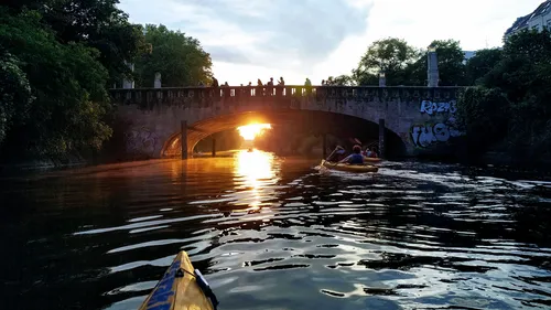Kajak nähert sich einer sonnigen Steinbrücke.