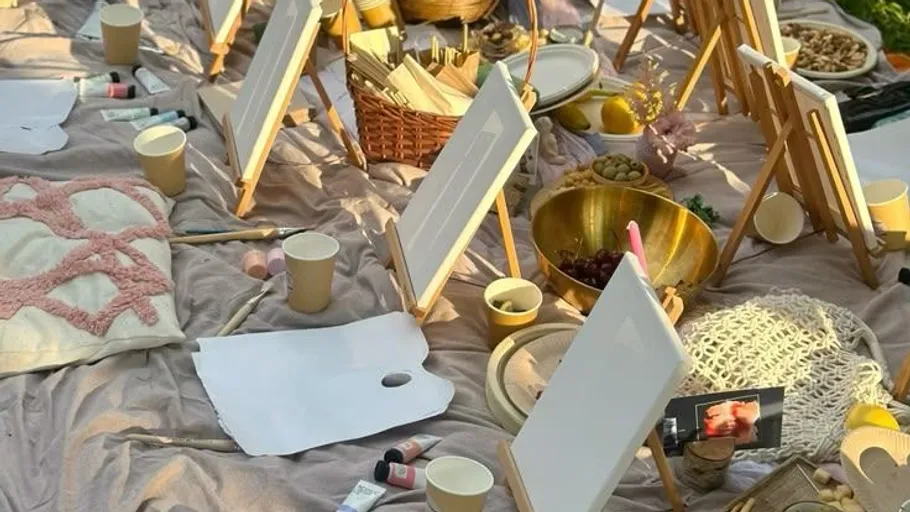 Art easels on a cloth with painting supplies.