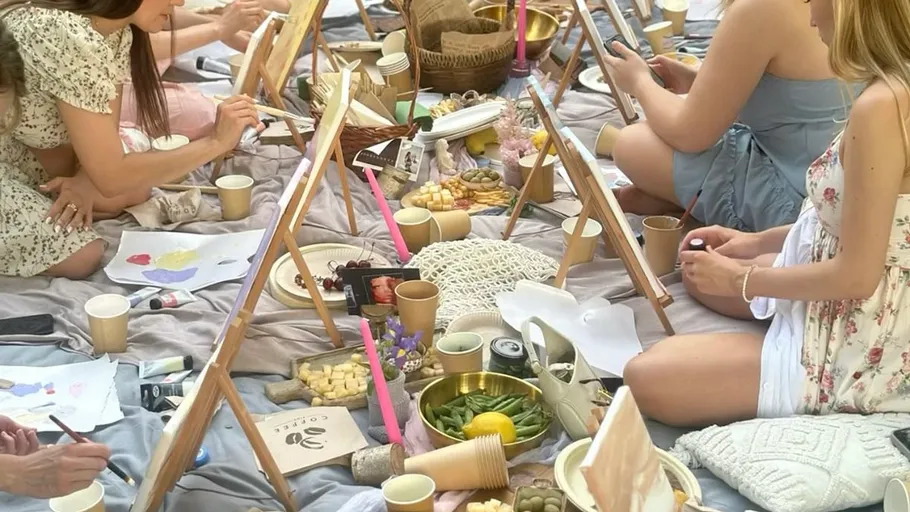 Leute malen bei einem Picknick.