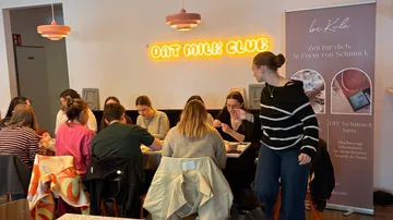 People crafting jewelry in a cozy cafe.
