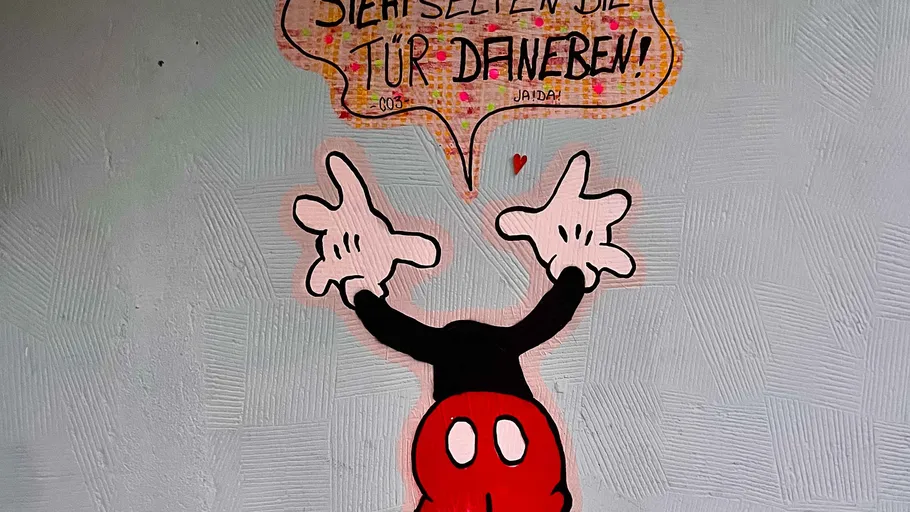 Comicfigur mit Sprechblase an der Wand.