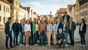 Group of people posing on cobblestone street.