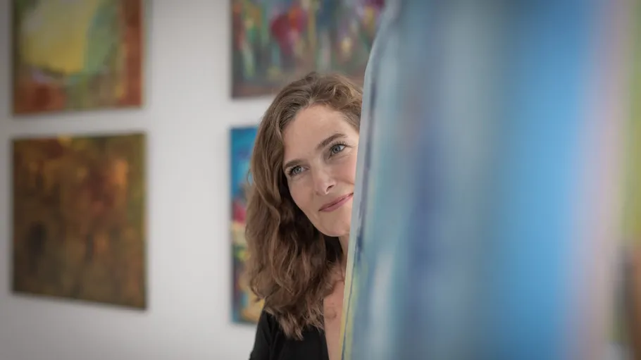Frau betrachtet bunte Gemälde in Galerie.