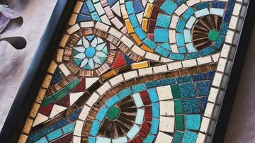 Bunte Mosaikkunst mit geometrischen Mustern ausgestellt.