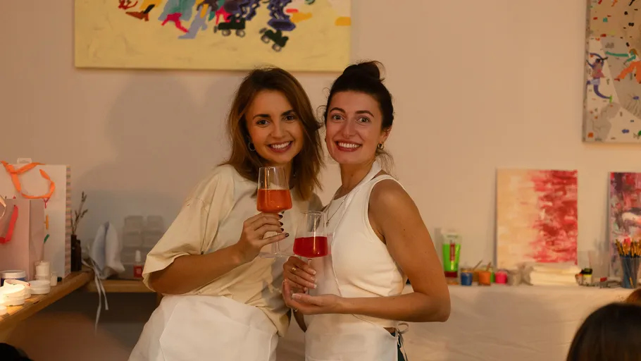 Zwei Frauen mit Getränken im Kunststudio.