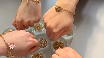 Hands with bracelets above glass bowls.