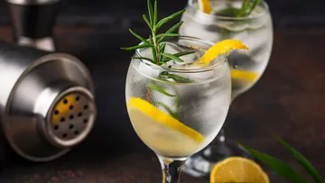 Zwei Gin-Cocktails mit Zitronen- und Rosmarin-Garnitur.