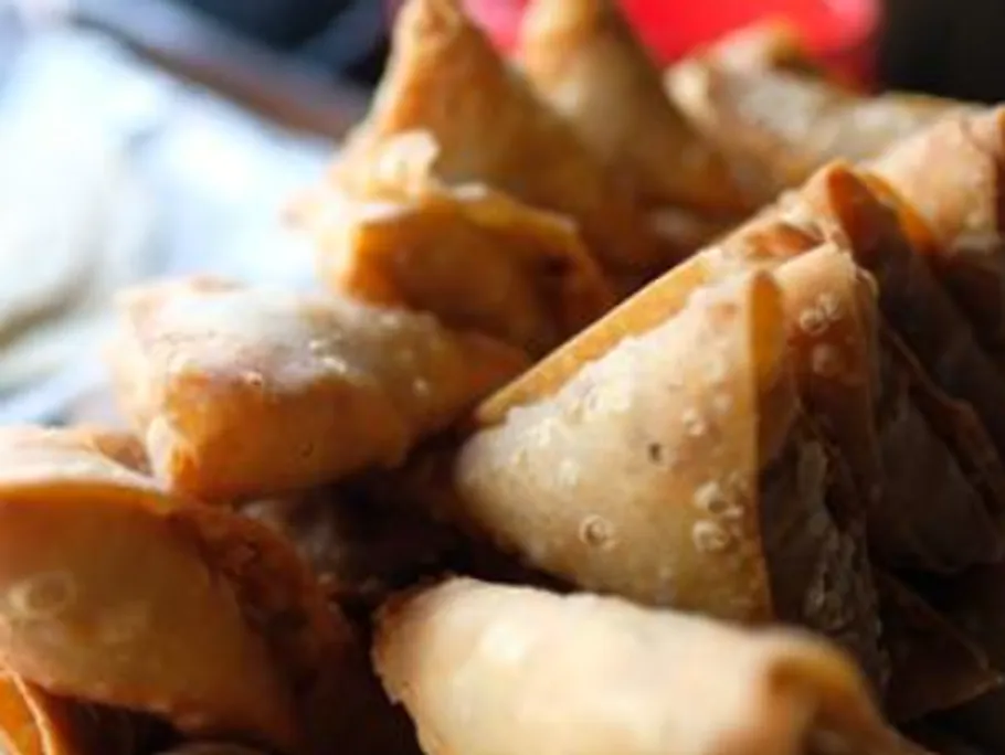 Fried dumplings lie on top of each other on a plate.