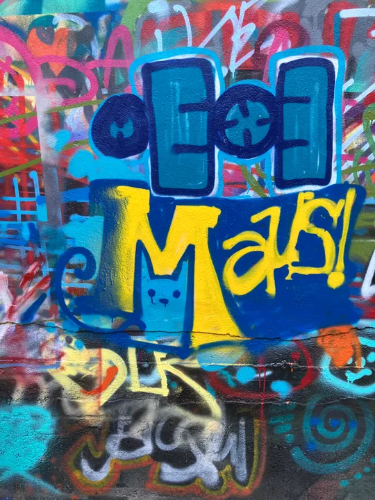 Bunte Graffiti mit abstrakten Formen und Buchstaben.