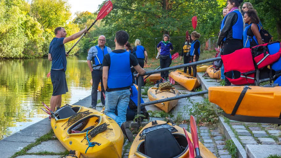 Menschen bereiten Kajaks am Fluss vor.