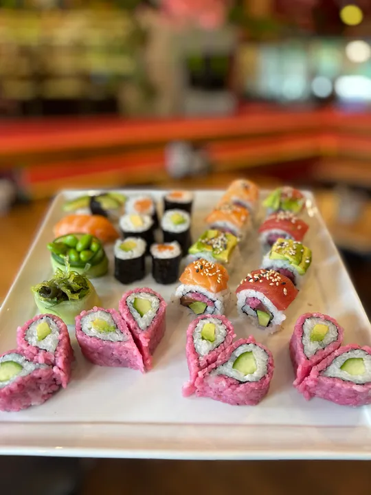 Verschiedene Sushi-Rollen auf einem weißen Teller.