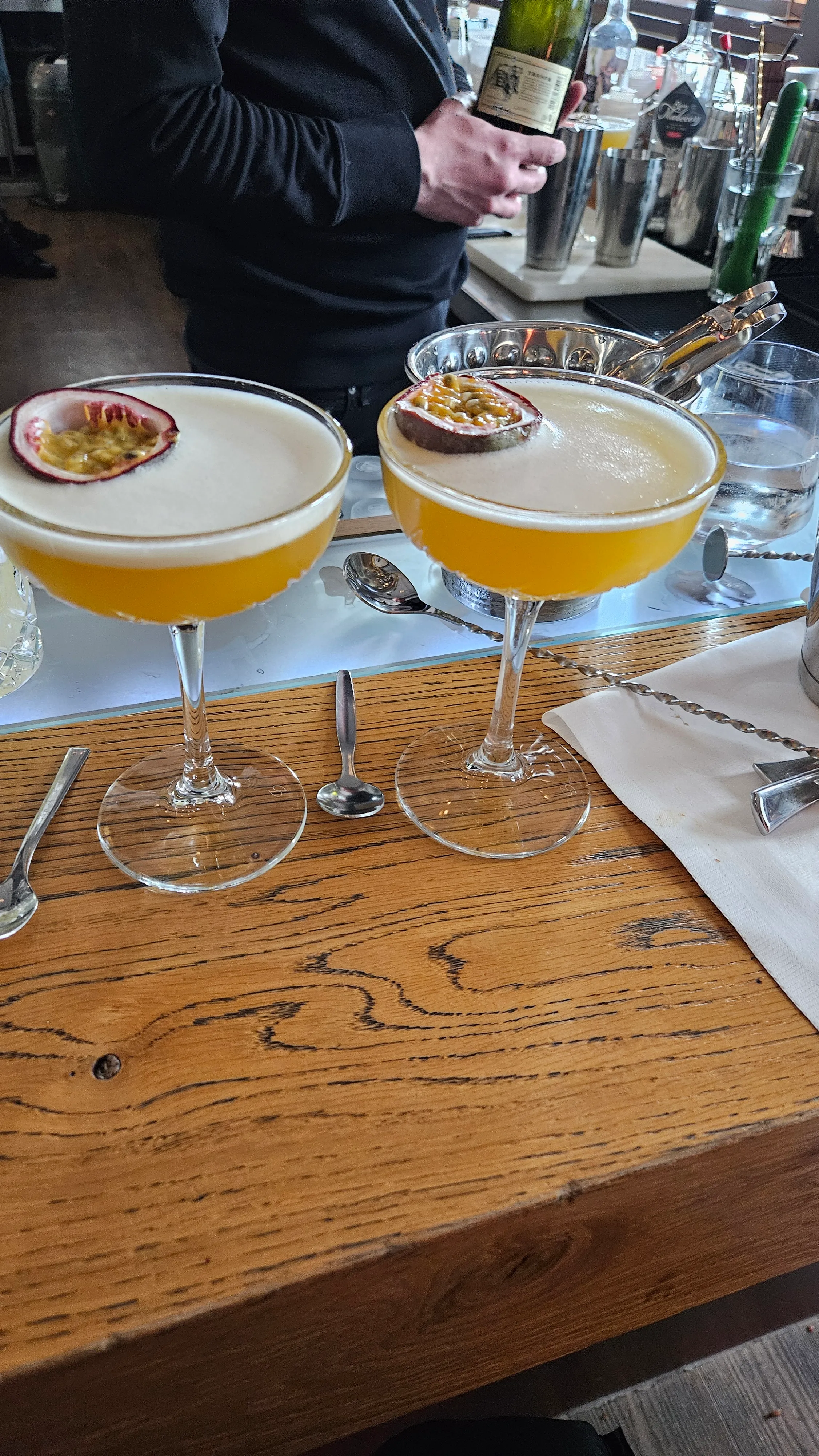 Zwei Cocktails mit Passionsfrucht an der Bar.