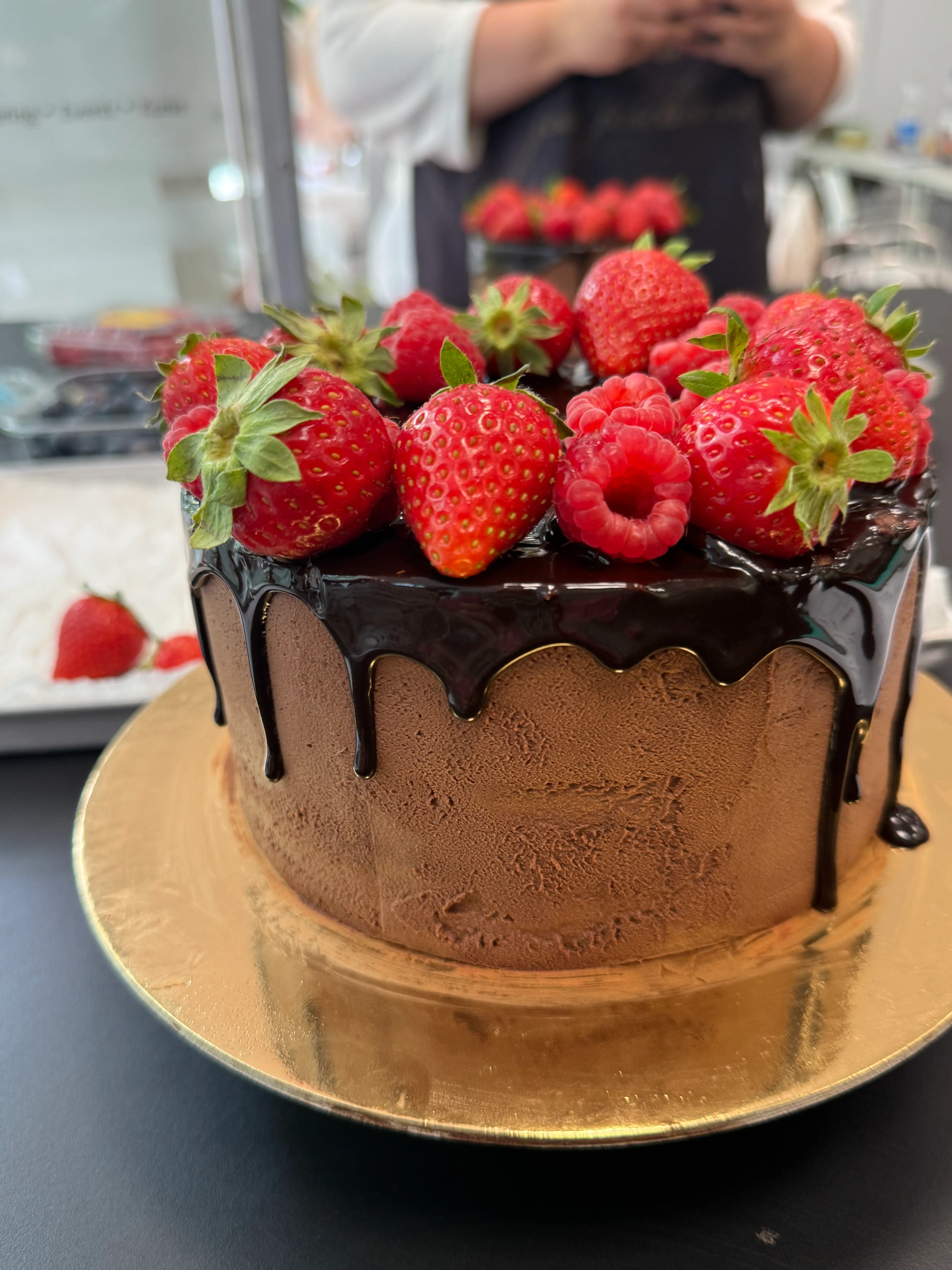 Chocolate cake with strawberries and raspberries on top.