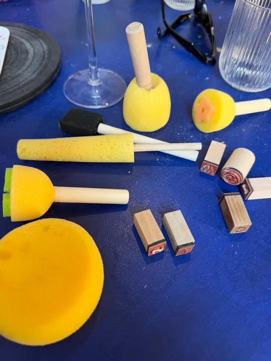 Craft supplies and stamps on blue table.