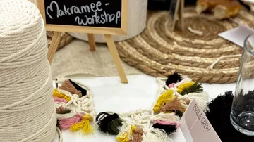 Macrame supplies on table with workshop sign.