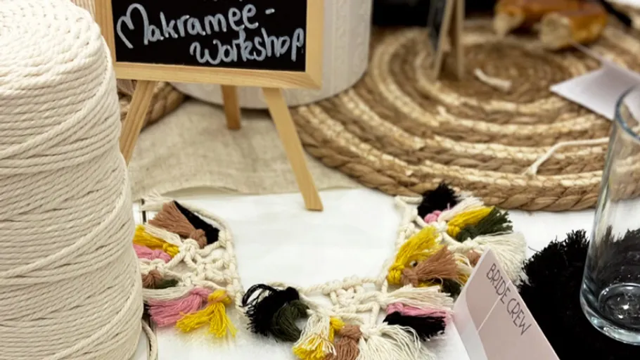 Makramee-Zubehör auf Tisch mit Workshop-Schild.