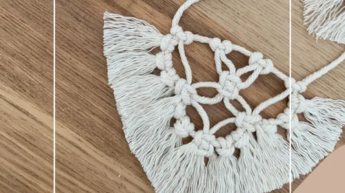 Macrame piece with fringes on wood surface.