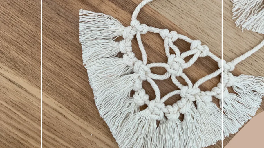 Macrame piece with fringes on wood surface.