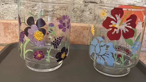 Zwei Gläser mit bunten Blumenmotiven.