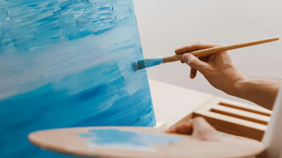 Hand malt blaue Leinwand mit Pinsel drinnen.