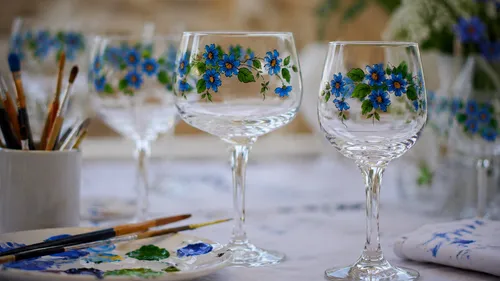 Weingläser mit gemalten blauen Blumen, Tischdekoration.