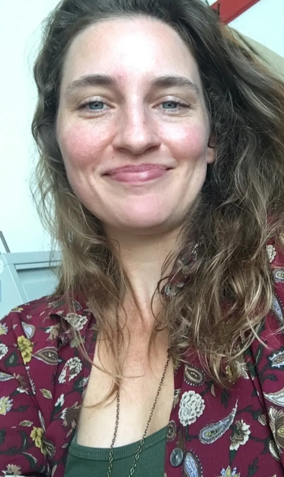 Lächelnde Frau mit langen Haaren drinnen.