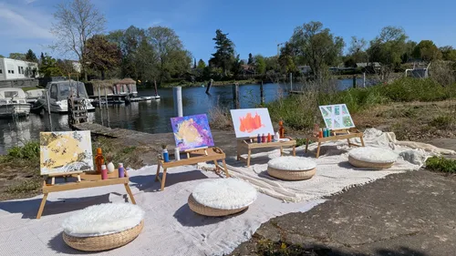 Kunststaffeleien mit Gemälden am Seeufer.