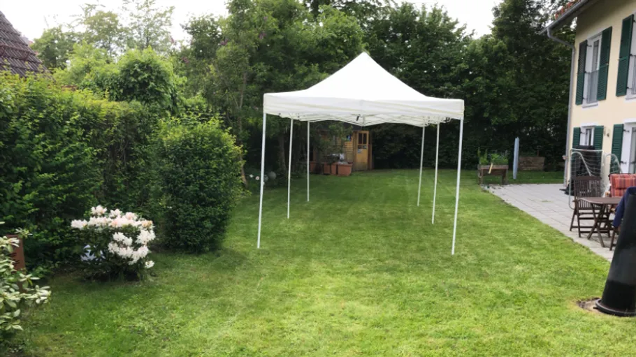 White canopy tent on green lawn.