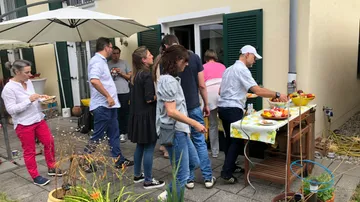 People gathered around a table at outdoor event.