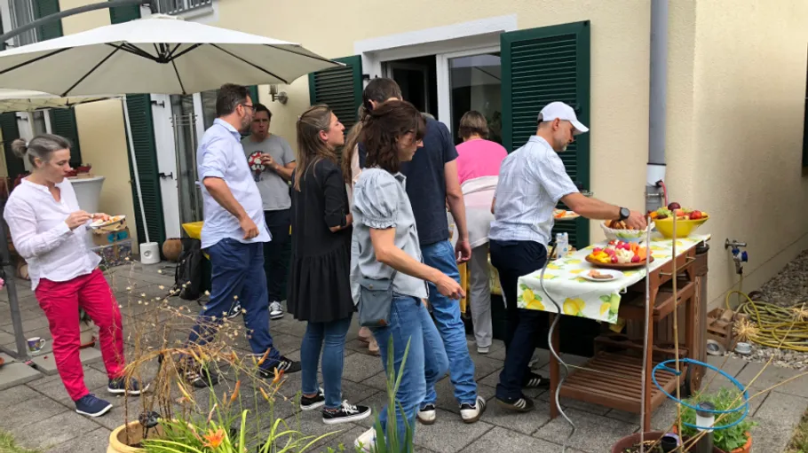 People gathered around a table at outdoor event.