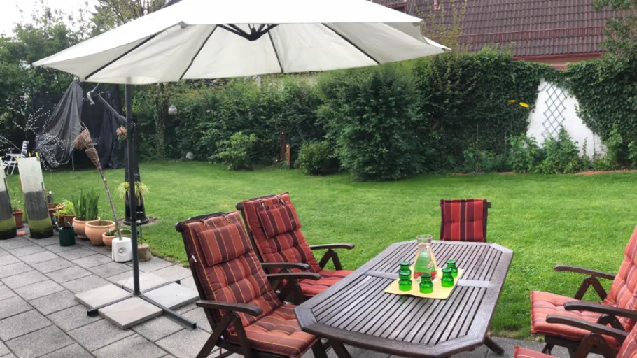 Garden patio with chairs and umbrella.