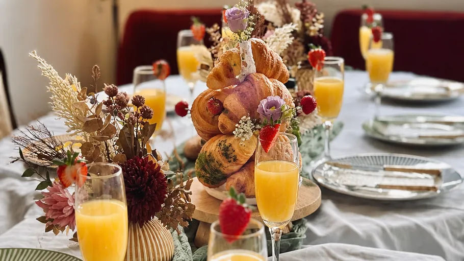 Breakfast table with croissants and juices.