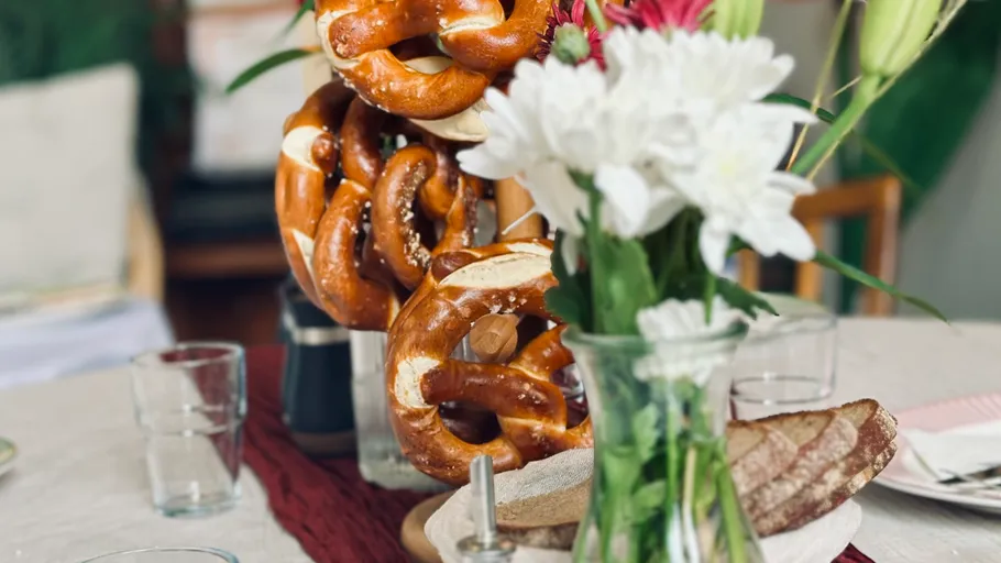 Pretzels and flowers on a dining table.