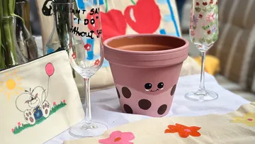 Decorated flower pot with glasses on a table.